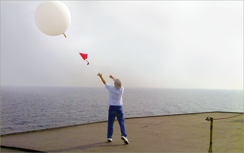 A researcher releases a weather balloon from the deck of a ferry on Lake Michigan